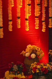 a bunch of flowers on a table in front of a red wall